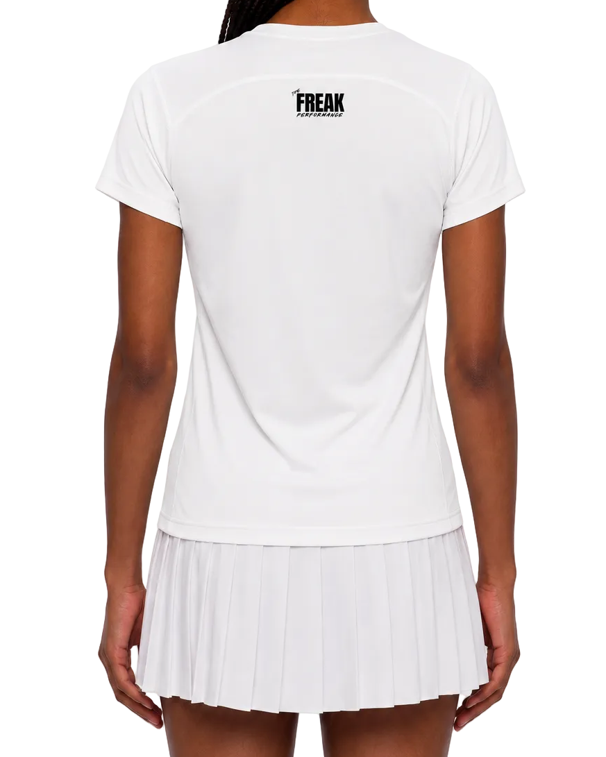 A woman viewed from the back wearing a white short-sleeve athletic top and matching white pleated tennis skirt. The top has a small black 'FREAK' logo centered on the upper back.
